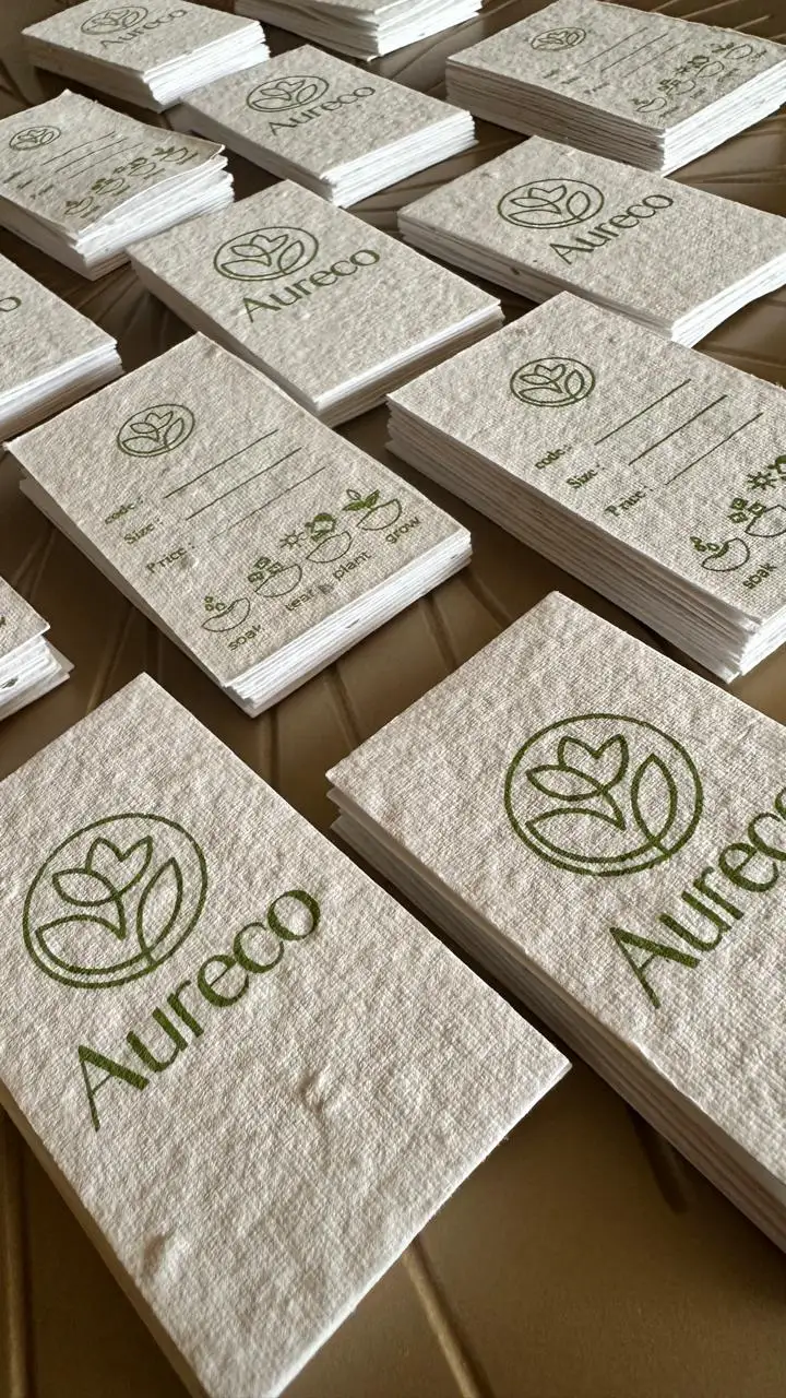 Custom hang tags for a clothing brand, printed on plantable seed paper and tied with cotton string.